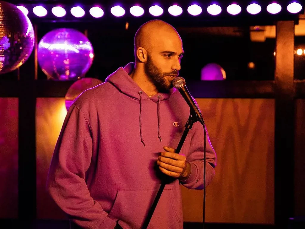 Dylan Palladino performing stand up comedy on baby shower