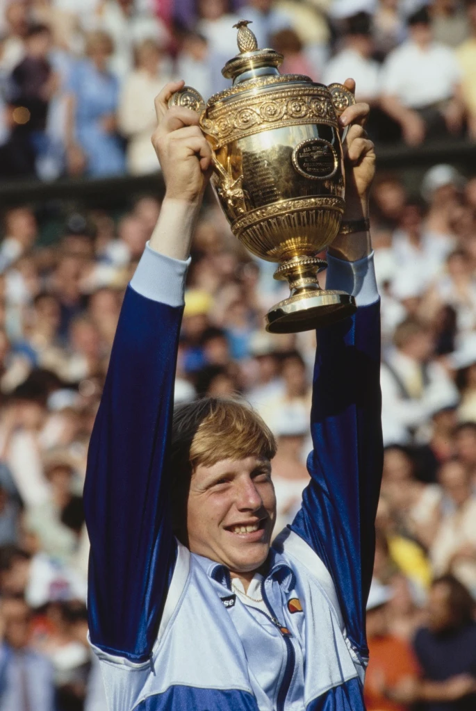 Boris Becker hoists 1985 Wimbledon trophy.